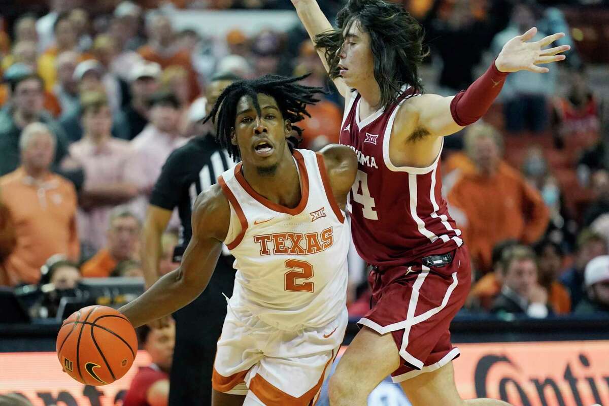 Texas guard Marcus Carr (2) drives around Oklahoma guard Bijan Cortes (14) during the second half of an NCAA college basketball game, Tuesday, Jan. 11, 2022, in Austin, Texas. (AP Photo/Eric Gay)