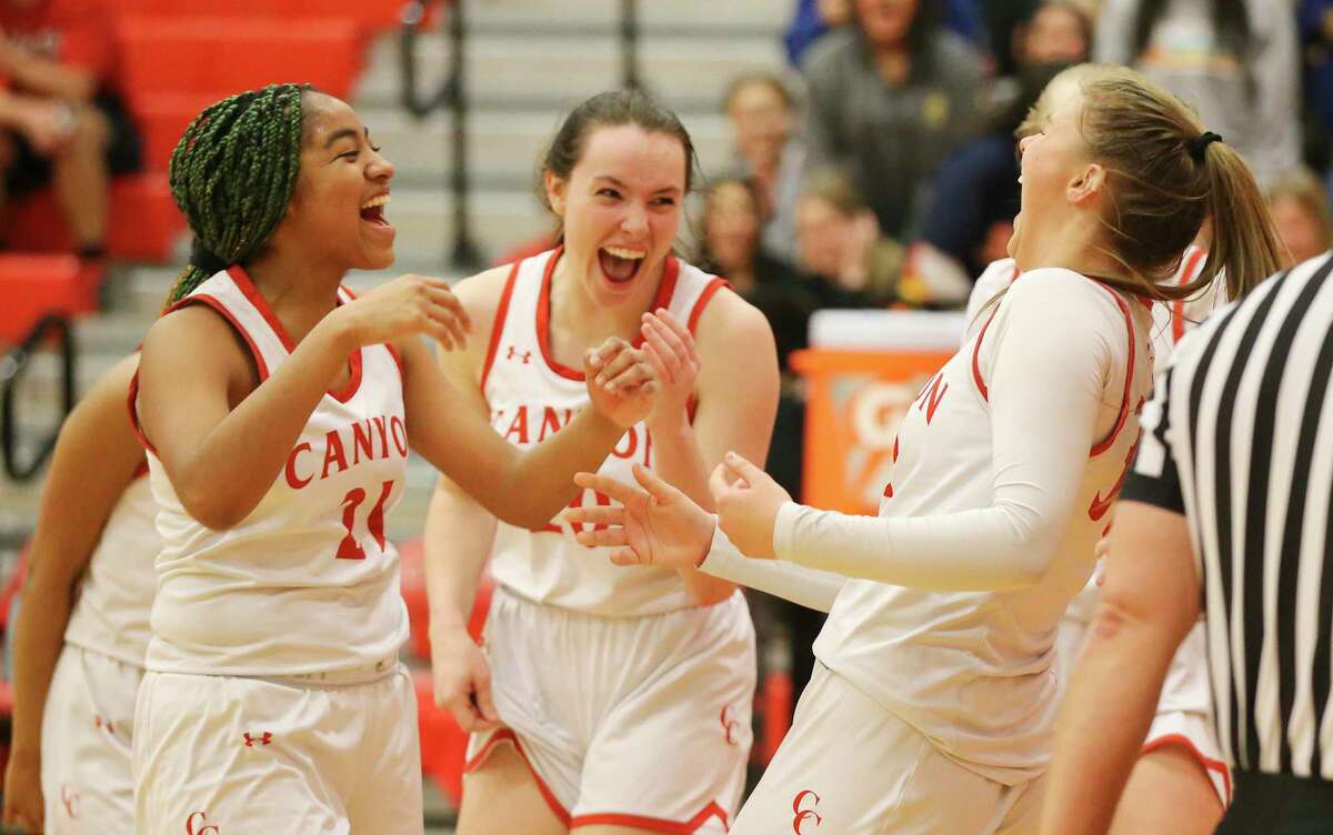 Canyon players Keanna Black (11), Kyla Malone (20) and Madison Parham (right) react after Parham scores on a play against Boerne Champion in girls basketball in New Braunfels on Tuesday, Jan. 11, 2022. Canyon defeated Champion, 57-55, in overtime.