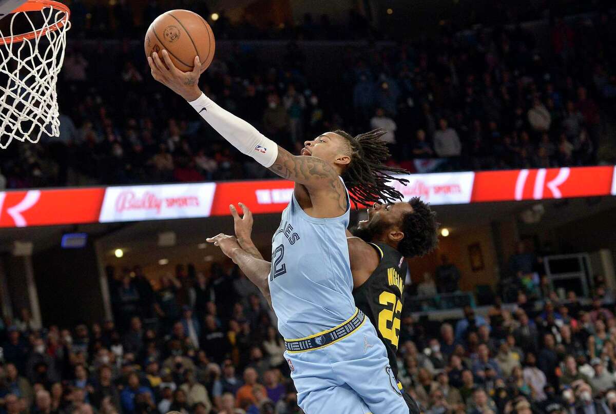 Memphis Grizzlies guard Ja Morant (12) shoots against Golden State Warriors forward Andrew Wiggins (22) in the second half of an NBA basketball game Tuesday, Jan. 11, 2022, in Memphis, Tenn. (AP Photo/Brandon Dill)
