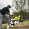A man puts down a note at a makeshift memorial near the site along Park Manor Drive and Markwood Lane where a 15-year-old girl was shot and killed over night, Wednesday, Jan. 12, 2022, in Houston.
