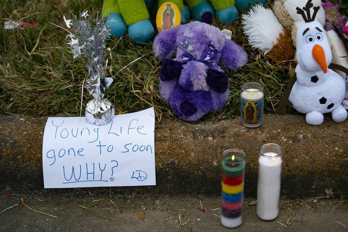 A man puts down a note at a makeshift memorial near the site along Park Manor Drive and Markwood Lane where a 16-year-old girl was shot and killed over night, Wednesday, Jan. 12, 2022, in Houston.