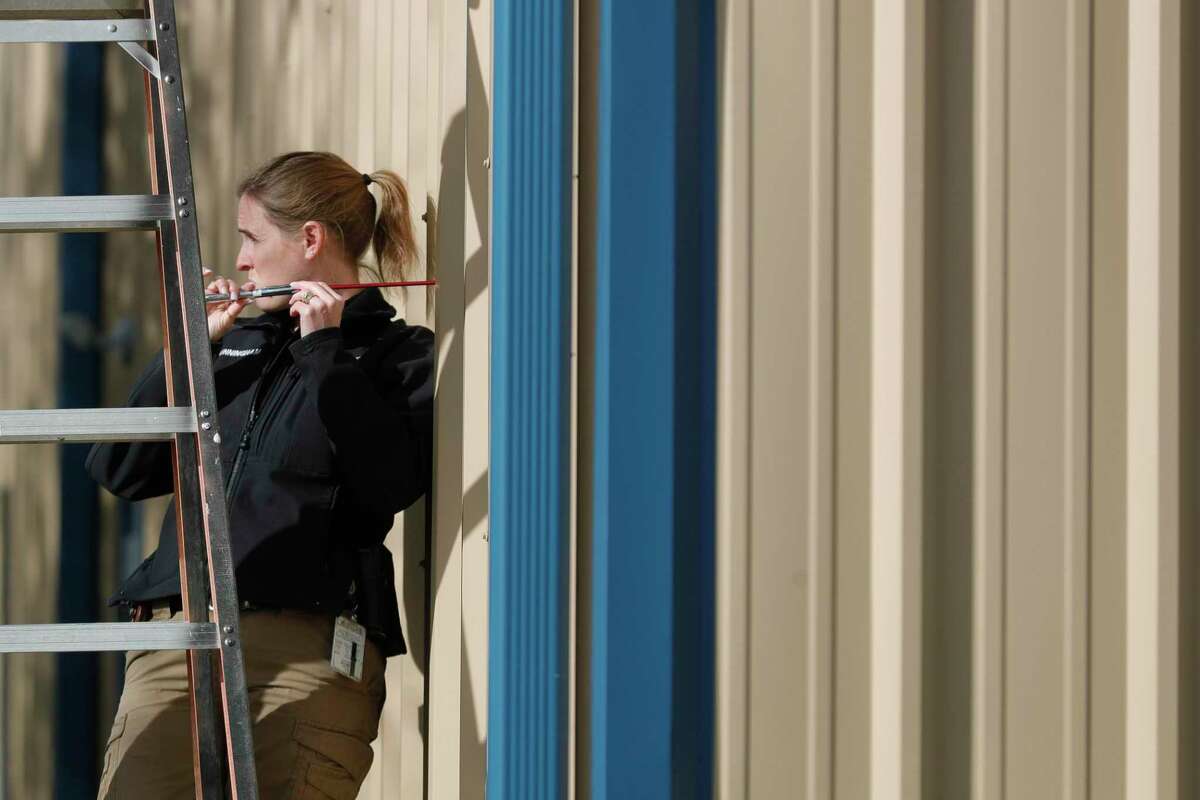Conroe Police Officer Cassandra Cunningham, with the department’s crime scene investigation unit, works a scene of a shooting at Hopewell Baptist Church, Tuesday, Jan. 11, 2022, in Conroe. Nearly two dozen bullets landed throughout the church on Jan. 8. No injuries were reported.