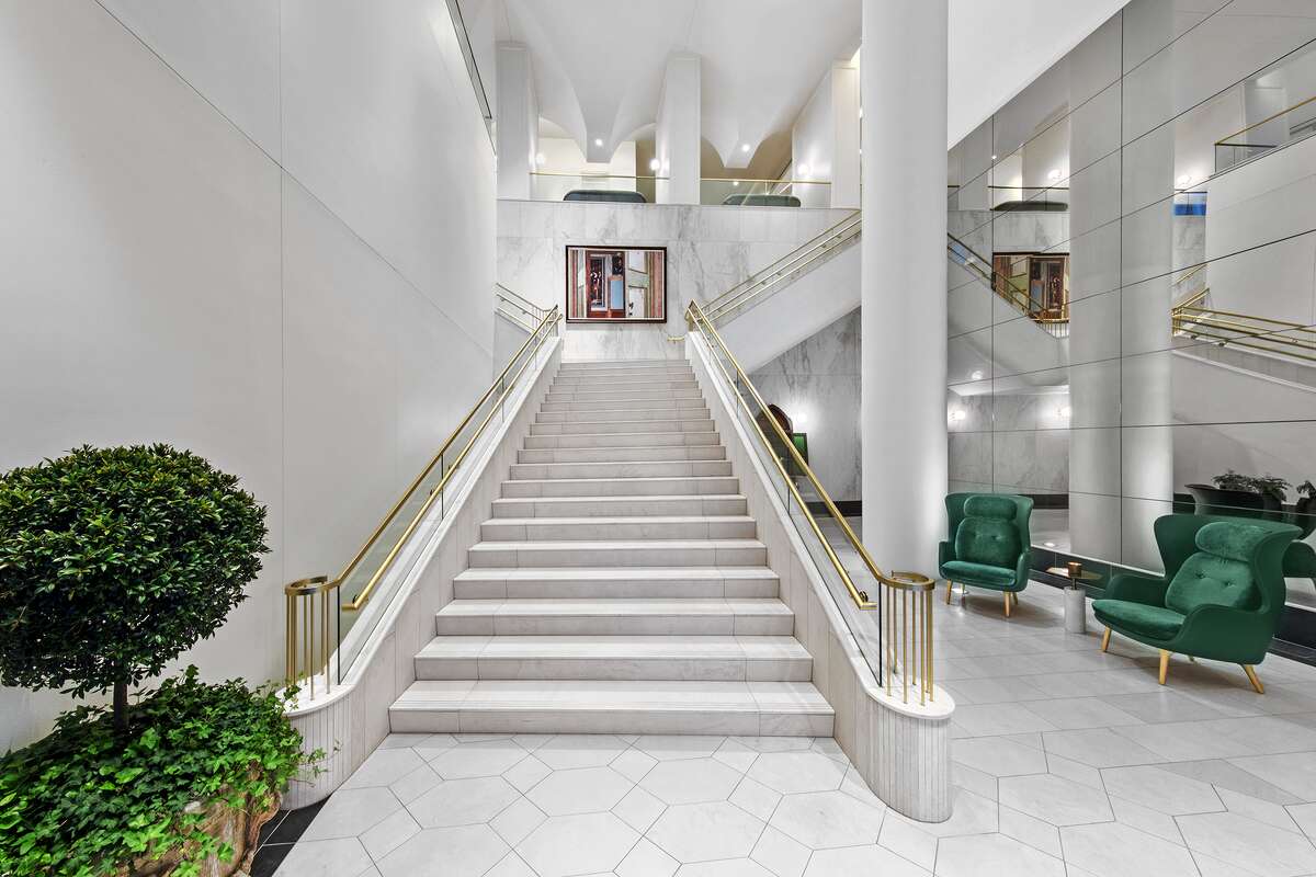 The entrance to The Laura Hotel, featuring a white marble staircase with gold accents