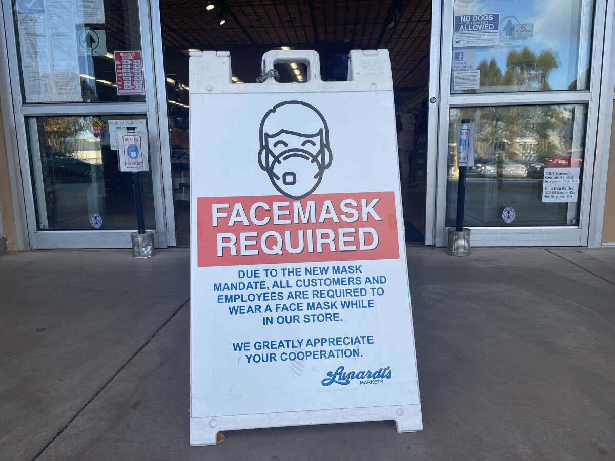 A sign informs customers that a face mask is required to enter a grocery store in Millbrae, Calif., on Dec. 31, 2021.