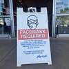 A sign informs customers that a face mask is required to enter a grocery store in Millbrae, Calif. on Dec. 31, 2021.
