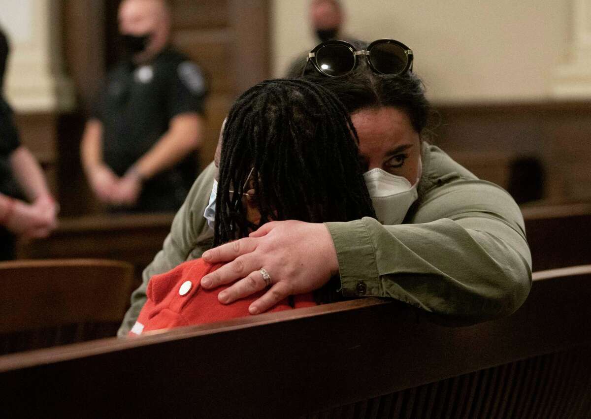 A family member who is crying with relief is consoled as James White is sentenced to life in prison without parole before Rensselaer County Judge Debra Young at the Rensselaer County Courthouse on Wednesday, Jan. 12, 2022 in Troy, N.Y. White, a 42-year-old Schenectady man, was convicted late last year of the killings of two women and two children in a Troy apartment.