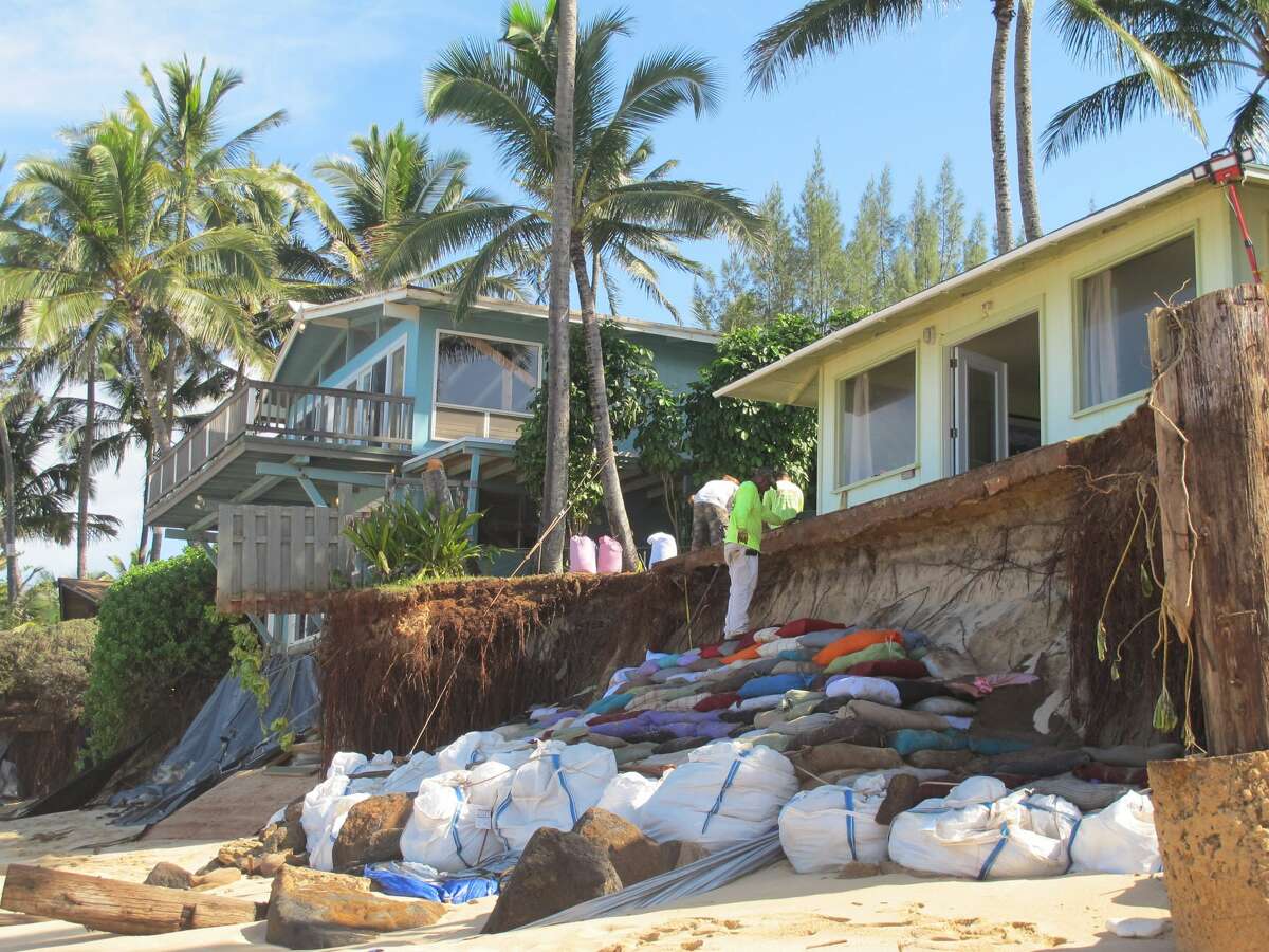 Sandbags are piled up in front of properties damaged by severe beach erosion in the Rocky Point neighborhood of Oahu's North Shore in Haleiwa, Hawaii on Tuesday, Dec. 31, 2013. Some property owners want to be able to install a seawall or something similar to protect their property, but scientists say doing so could lead the sand on the nearby coastline - including Sunset Beach, home to some of the world?’s top surfing contests - to disappear. (AP Photo/Audrey McAvoy)