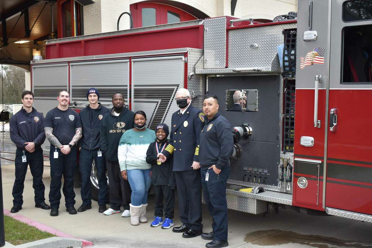Justin, his parents, Justin and Nicole, Fire Chief Scott Seifert, and the crew of Engine 74 C-Shift. Left to right: Firefighters Keenan Roche and Tyler Crane, Apparatus Operator Blake Thompson, Justin Clayton, Sr., Nicole Clayton, Justin Clayton, Jr., Spring Fire Chief Scott Seifert and Captain Walter Juarez.