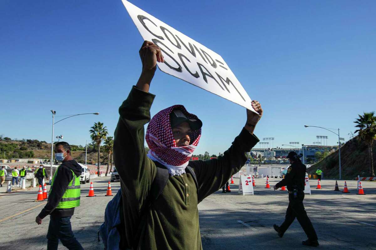 Scott Bayou protests in front of a vaccination site at Dodger Stadium in Los Angeles on Jan. 30, 2021.
