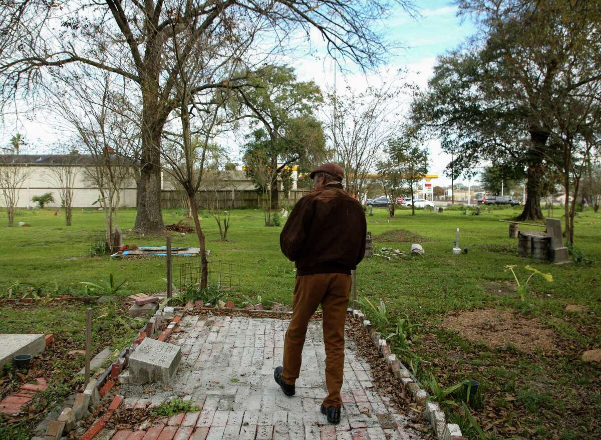 Dr. Woodrow Jones walks toward the gravesite of Alexander K. Kelley - who founded Evergreen Negro Cemetery - on Tuesday, Jan. 11, 2022, in Fifth Ward. The historic cemetery sits unceremoniously on a lot next to a Shell gas station on Lockwood Avenue, with no fences or public bodies officially responsible for its upkeep. Jones is one of the leaders of Project RESPECT, a group that tries to maintain the land of historically Black cemeteries around Houston.