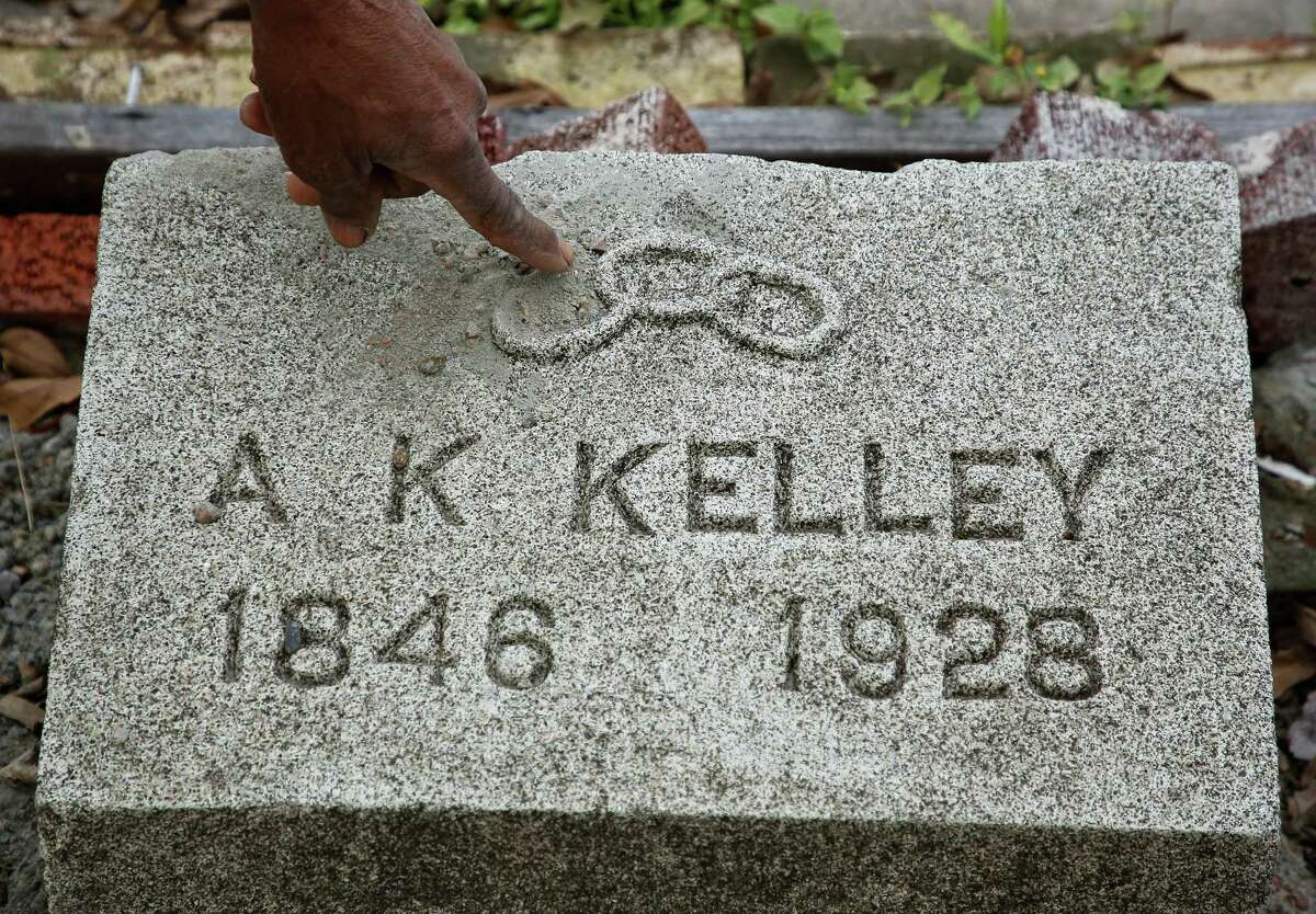 Dr. Woodrow Jones points to the chain links found on the tombstone of Alexander K. Kelley, who founded Evergreen Negro Cemetery in Fifth Ward.
