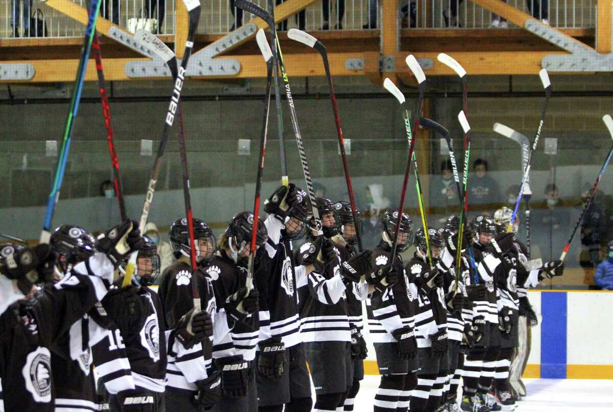 Brunswick hockey team players hold up their hockey sticks during a moment of silence before a game against Millbrook at Hartong Rink in Greenwich on Wednesday. The moment of silence was held in memory of St. Luke's Teddy Balkind, who died Thursday at rink in a junior varsity game against Brunswick.