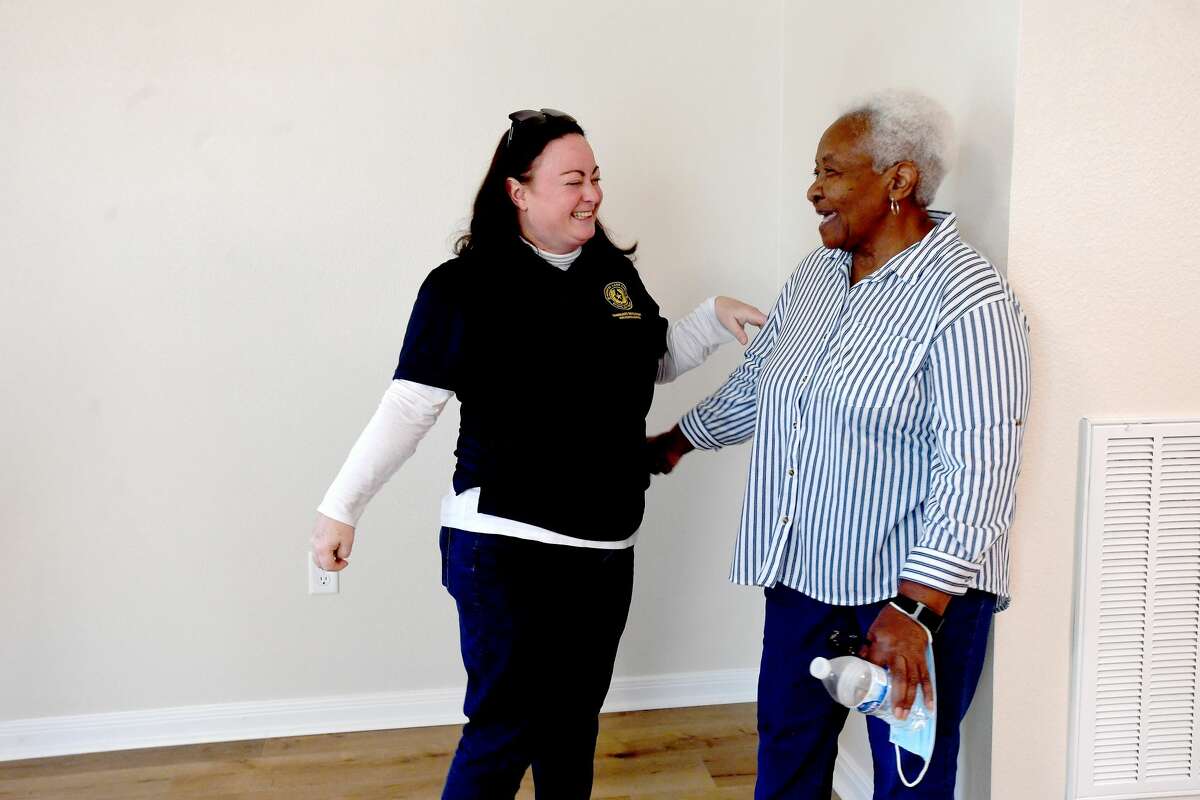 Ava Williams gets her new house keys from GLO's Brittany Eck as she met with members of the office and home builders for a new home welcome in Beaumont Wednesday. Just over a month ago, Williams gathered with the group as demolition began on her long-time residence, which was damaged by flooding during Tropical Depression Imelda. She was the first in the region to get a new elevated home built through the GLO's Imelda-targeted funding. Photo made Wednesday, January 12, 2022 Kim Brent/The Enterprise