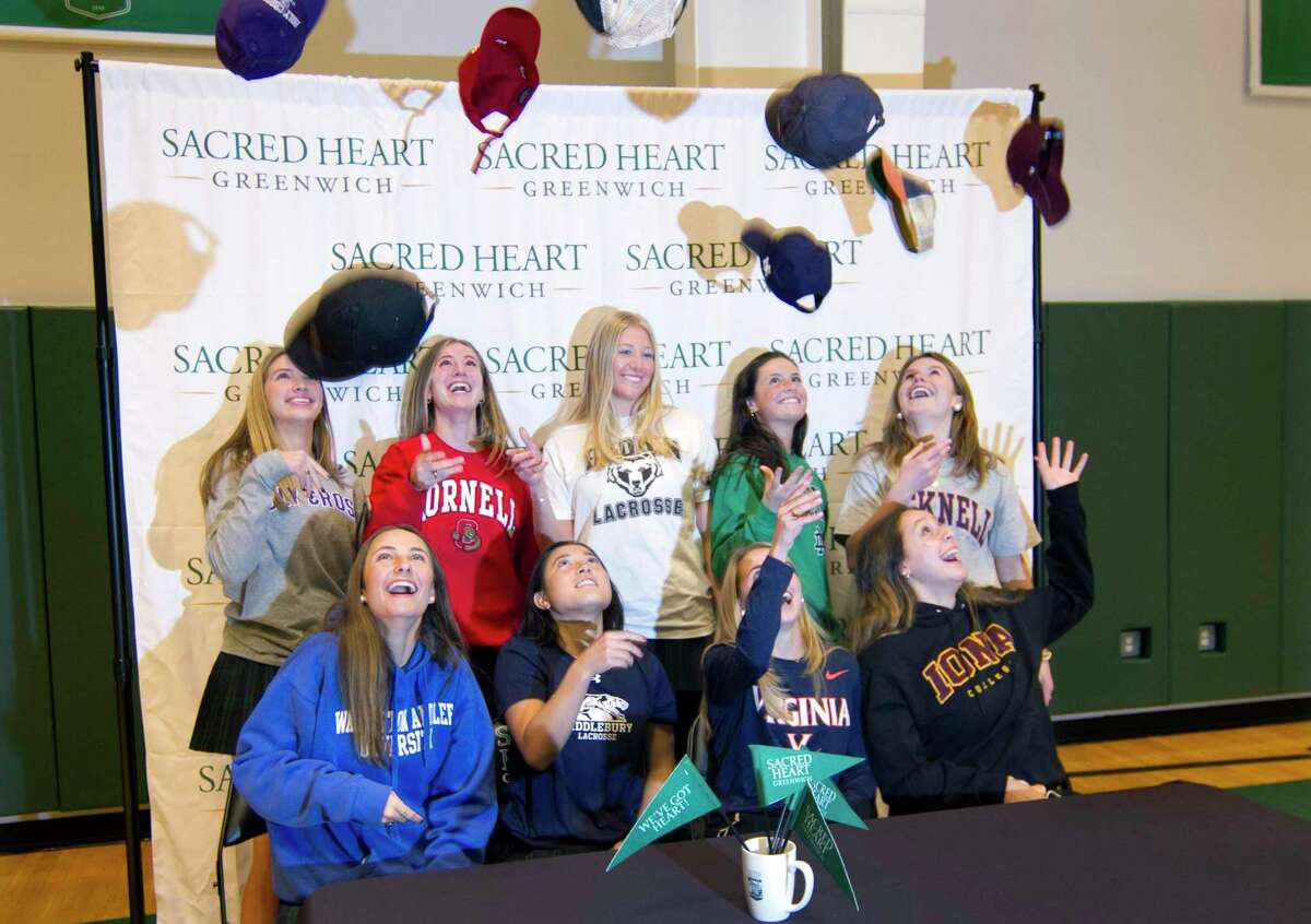 Nine Sacred Heart Greenwich students toss up their college caps to celebrate after a Commitment Night signing ceremony at the school in Greenwich on Wednesday. The school has 10 participants going to play a variety of college sports at D1 and D3 levels. Seated from left to right is Chelsea Hyland, Lauren Guiriceo, Caroline Nemec and Bella Adams. Standing from left to right is Kate Hong, Justine Hounsell, Annie O’Connor, Franny O’Brien and Libby Kaseta. Not present is Erin Griffin.