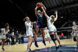 Connecticut forward Olivia Nelson-Ododa (20) shoots between Butler defenders forward Alex Richard, left, and Ellen Ross (25) in the first half of an NCAA college basketball game in Indianapolis, Wednesday, Jan. 12, 2022. (AP Photo/AJ Mast)