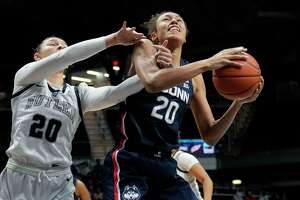 Connecticut forward Olivia Nelson-Ododa, right, is fouled by Butler forward Alex Richard in the first half of an NCAA college basketball game in Indianapolis, Wednesday, Jan. 12, 2022. (AP Photo/AJ Mast)