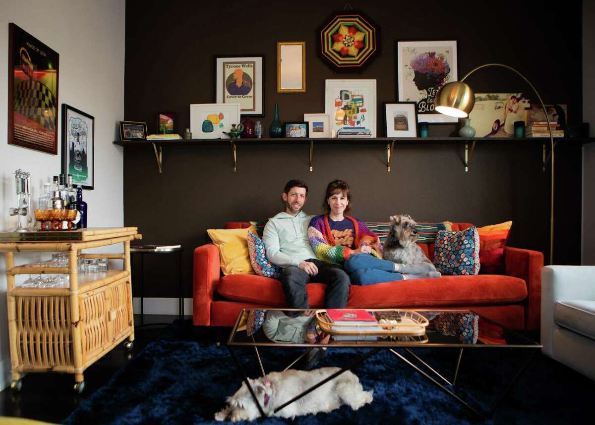 Michael Crone, 34, Natalie Wells, 33, and their dogs Lizzie, 10, and Oliver, 9, at their townhome’s living room, Wednesday, Jan. 12, 2022, in Houston. The couple bough the townhome in EaDo in March 2021.