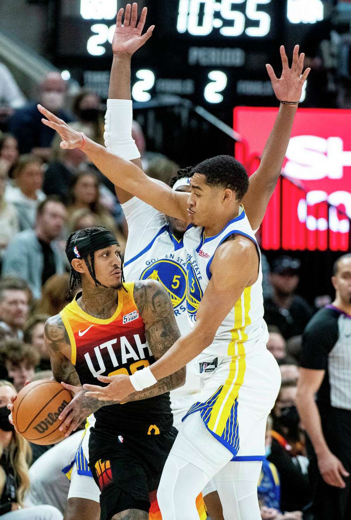 Utah Jazz guard Jordan Clarkson is contested by Warriors guard Jordan Poole (front) and center Kevon Looney (5).