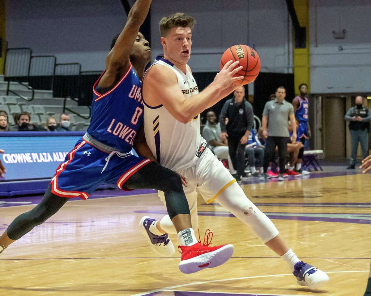 UAlbany graduate student Matt Cerruti drives to the basket in front of UMass Lowell graduate student Justin Faison. Cerruti said the team is trying to stay "even-keeled" despite its three-game winning streak.