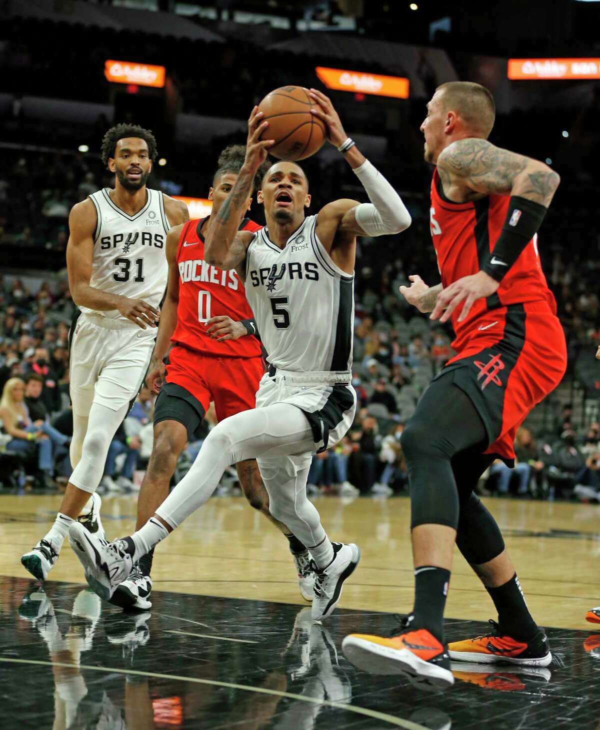 San Antonio Spurs guard Dejounte Murray #5 drives for a basket past Houston Rockets Daniel Theis #27. BKN Spurs-Rockets Takeaways at A&T Center on Tuesday, Jan. 12,2022.