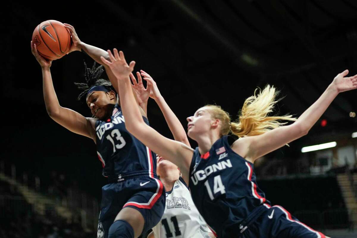 UConn guard Christyn Williams (13) and forward Dorka Juhasz (14) go after a rebound in front of Butler guard Tenley Dowell (11) in Indianapolis on Wednesday. UConn won 92-47.