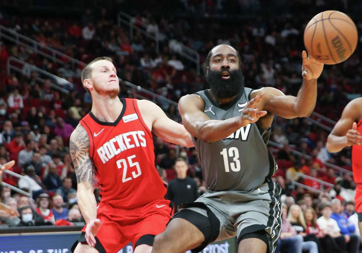 Brooklyn Nets guard James Harden (13) dishes off the ball as Houston Rockets guard Garrison Mathews (25) applies pressure at the Toyota Center in Houston on Wednesday, Dec. 8, 2021. Rockets beat the Nets 114-104 to continue their winning streak to seven.