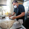 Owner and chef Sachin Chopra works on shaping some sourdough bread in the kitchen of All Spice restaurant in San Mateo, Calif. on Jan. 11, 2022.