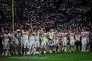 Fans turn on their cell phone lights as Utah players signal during the second half in the Rose Bowl NCAA college football game against Ohio State Saturday, Jan. 1, 2022, in Pasadena, Calif.