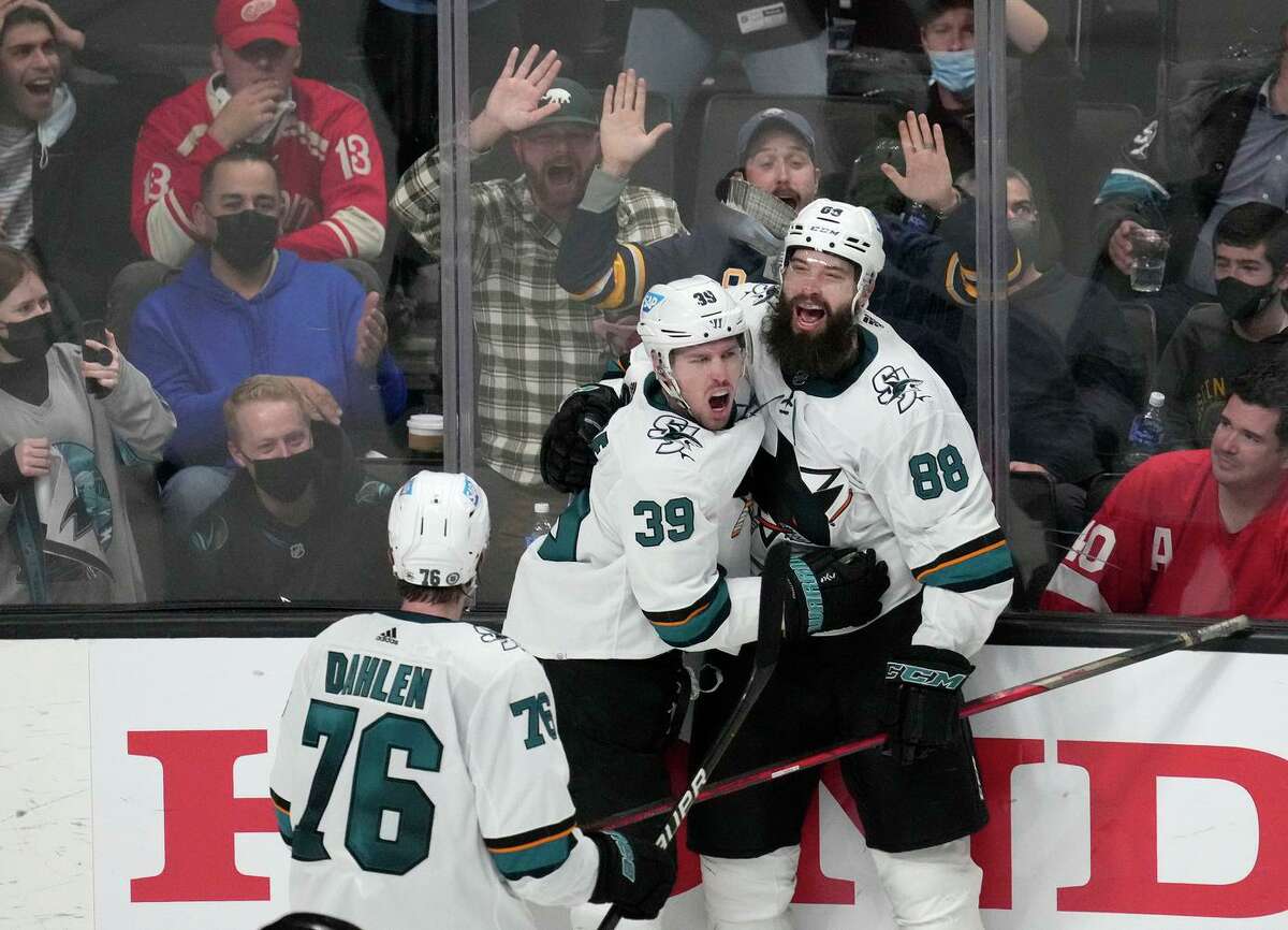 Brent Burns, right, embraces teammate Logan Couture after Couture’s overtime goal — on which Burns had an assist — beat Detroit on Tuesday night.