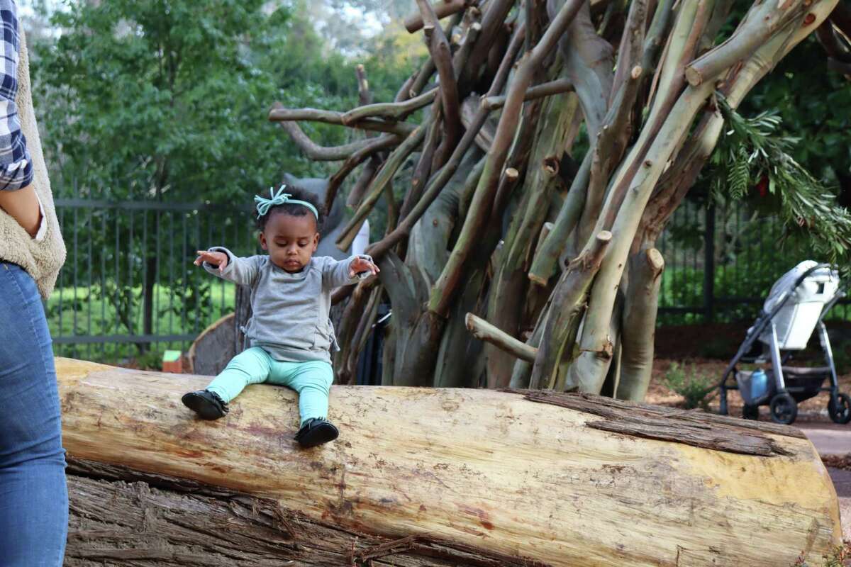 Leona Adams, 17 months, sits on one of the many repurposed logs at the California Academy of Sciences Wander Woods play space on Thursday, Jan. 13, 2022, in San Francisco.