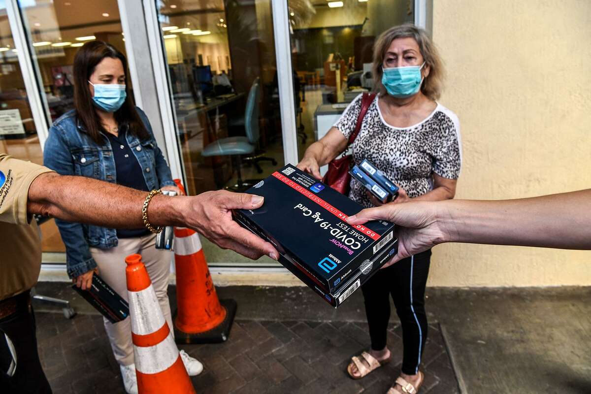 Employees of the Miami-Dade Public Library System distribute Covid-19 home rapid test kits in Miami, Florida, on Jan. 8, 2022. (Chandan Khanna/AFP via Getty Images/TNS)