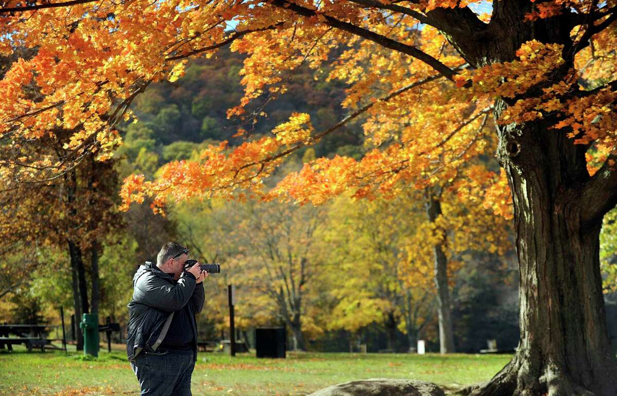 Dennis Mitchell of Sydney, Australia, stops at Squantz Pond in New Fairfield on Oct. 24, 2016, to photograph the fall foliage around the state park. Longer summer droughts are likely to cause stress on New England trees, diminishing their vibrant fall colors, according to a new study.