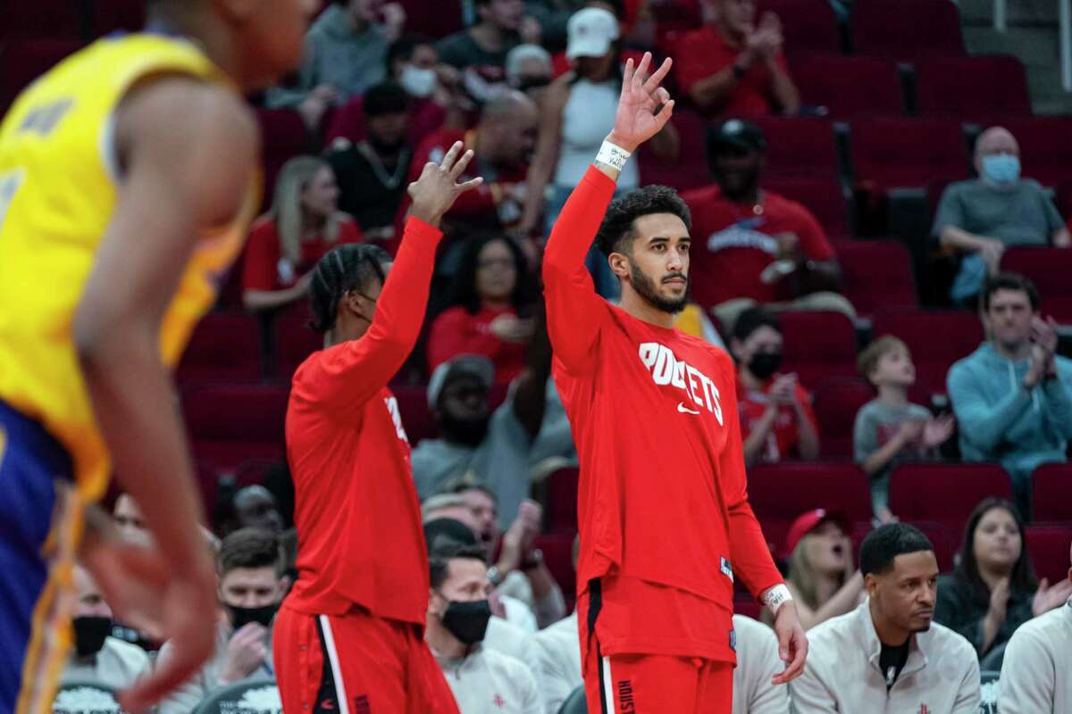 Houston Rockets guard Trevelin Queen celebrates a teammate’s three point shot from the bench during the first half of an NBA game between the Houston Rockets and Los Angeles Lakers on Tuesday, Dec. 28, 2021, at the Toyota Center in Houston.