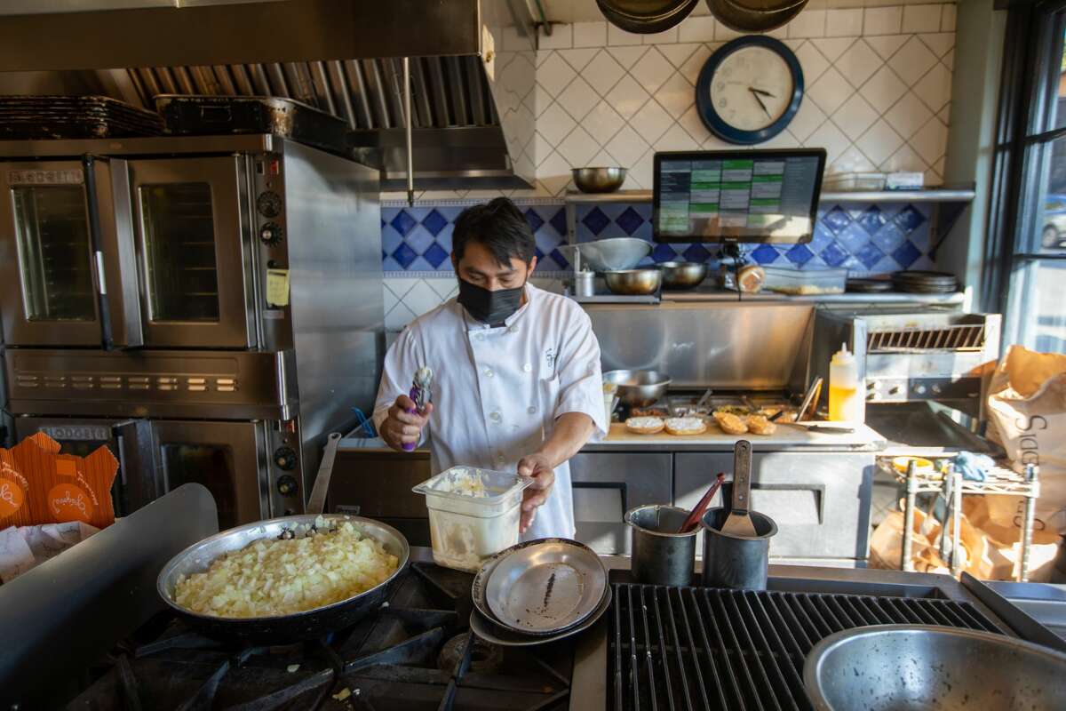 Cook Isiaias Alvarez prepares an order in the open kitchen at Grégoire take-out restaurant in Berkeley, Calif. on Jan. 12, 2022.