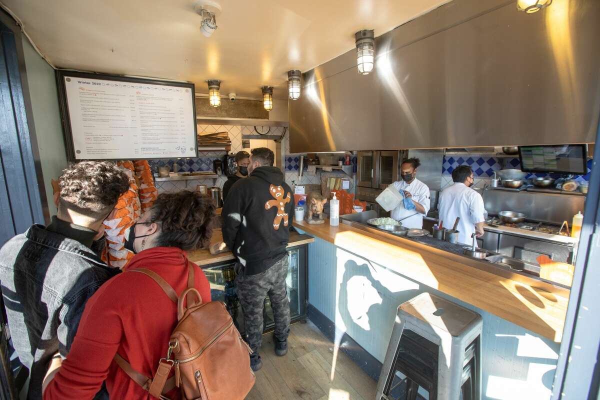 Customers wait to have their orders taken at the counter of Grégoire take-out restaurant in Berkeley, Calif. on Jan. 12, 2022.