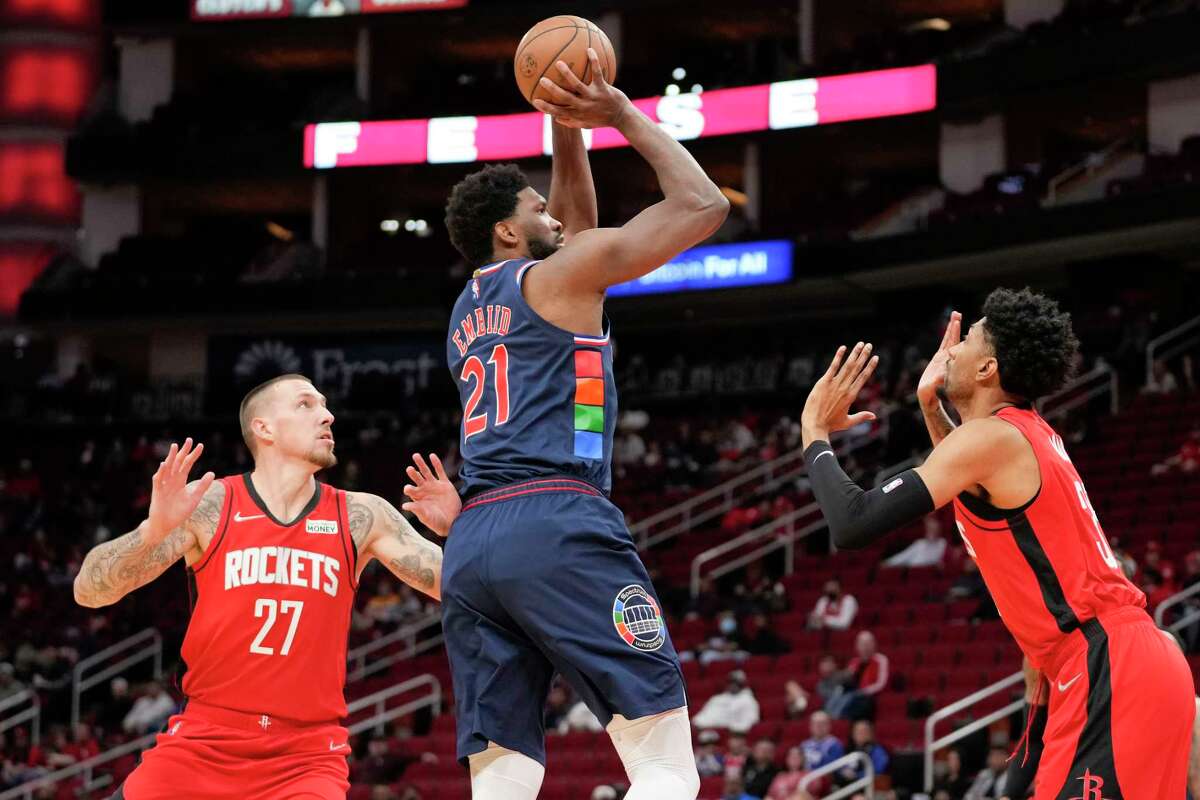 Philadelphia 76ers center Joel Embiid (21) shoots as Houston Rockets center Daniel Theis (27) and forward Christian Wood defend during the first half of an NBA basketball game, Monday, Jan. 10, 2022, in Houston. (AP Photo/Eric Christian Smith)