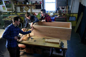 Bryan Atkins (left) and Jodi Kurtz (right) work with Marne Provost, an apprentice from Chicago, on a piece of furniture. (Photo by Jonathan Newton/The Washington Post via Getty Images)