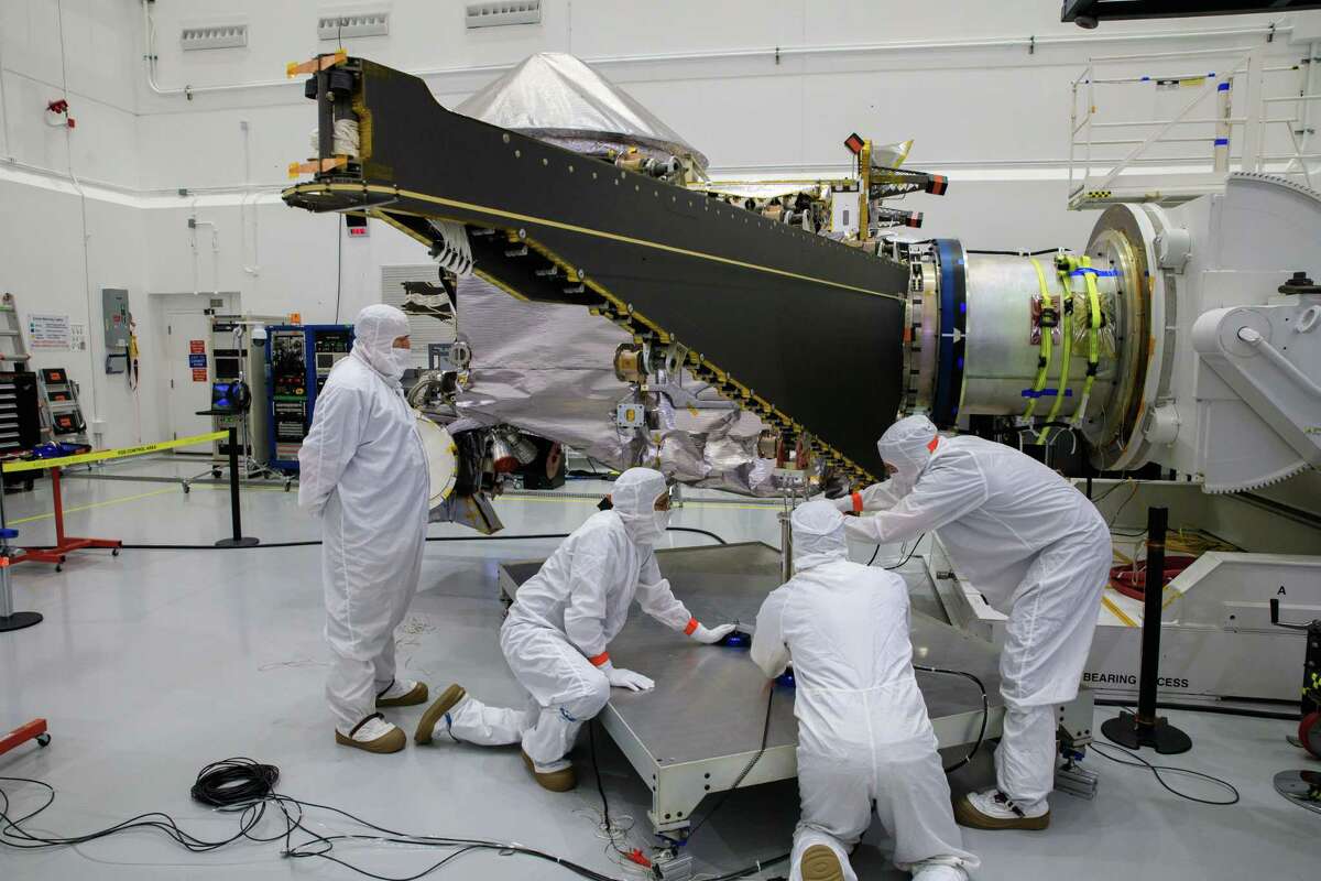 Workers inside the Astrotech Space Operations Facility in Titusville, Florida, work to open and extend one of the solar arrays on NASA's Lucy spacecraft on Aug. 19, 2021. After launching into space on Saturday Oct. 16, 2021, NASA reported that one of the spacecraft's solar arrays was not fully open.