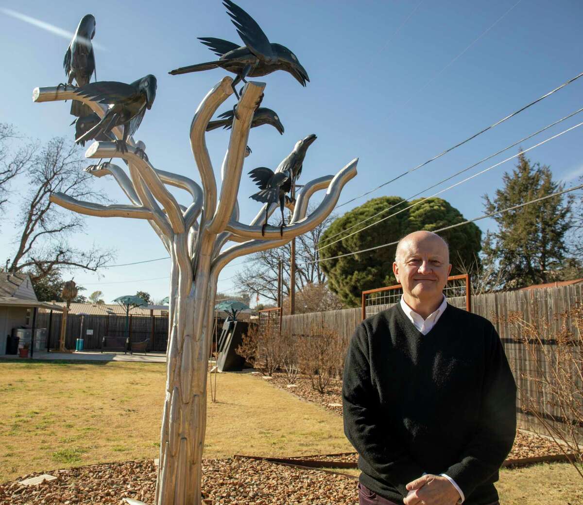 Arts Council of Midland executive director Danny Holeva poses for a portrait by "Tree Full of Wisdom" by Joe Barrington on Jan. 6, 2022, in the FMH Foundation Sculpture Garden. 
