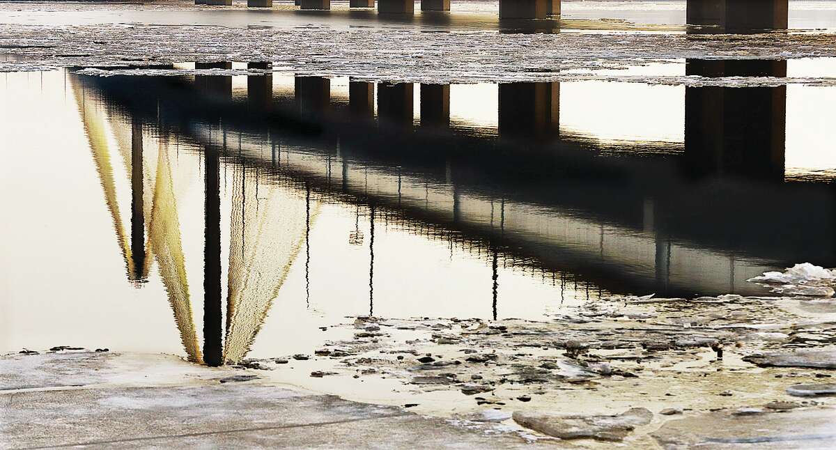 John Badman|The Telegraph A break in the ice on the Mississippi River Friday allowed for a calm reflection of the Clark Bridge.