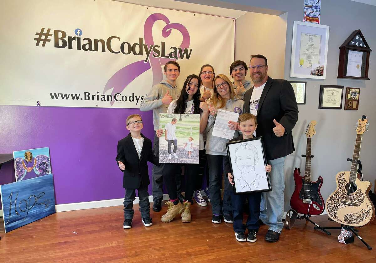 From left, Mason Morrissey, Sonny Lone Eagle, Maddy Frade (holding a photo of Brian Cody and his oldest daughter, Aubree), Rachael Morrissey, Tracey Morrissey, Strongbow Lone Eagle, Jayden Morrissey, and Coach Tony Morrissey