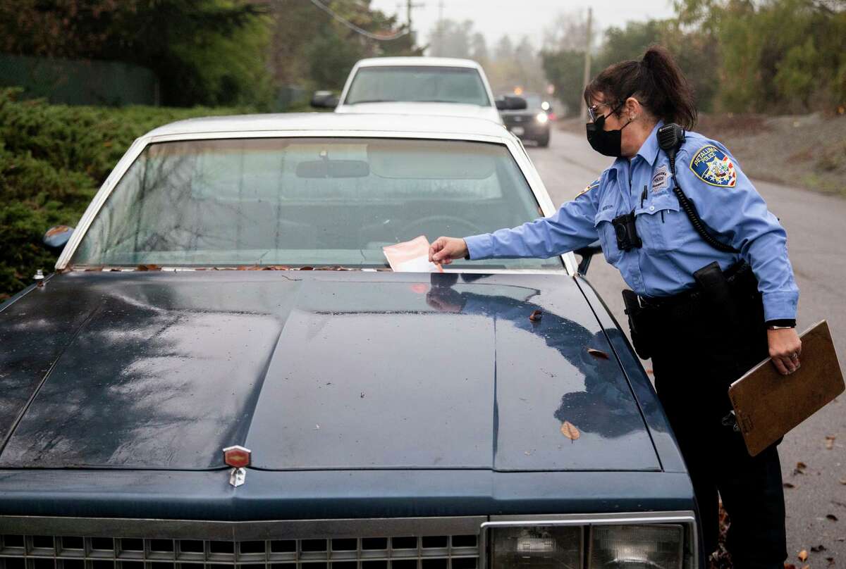 Petaluma police Officer Lisa Weston places a citation on an abandoned vehicle. Abandoned cars on city streets are a constant problem in Petaluma and other cities, causing blight and lowering property values.