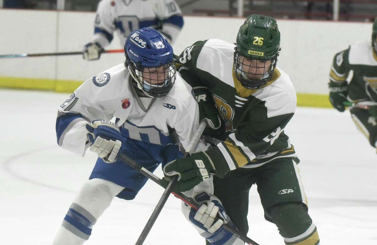 Darien’s Henry Gregory, left, and Bishop Hendricken’s Steven Nardelli battle for the puck during a game last Saturday.