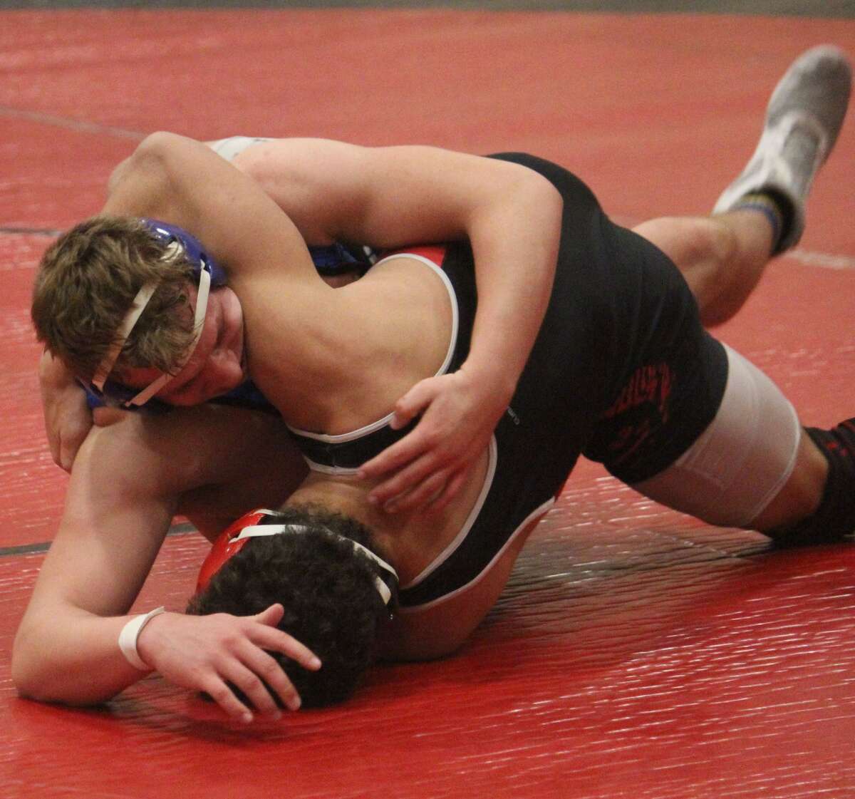 Evart's Sam Bailey (top) works on his opponent in a recent match.