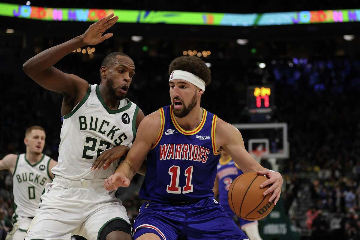 MILWAUKEE, WISCONSIN - JANUARY 13: Klay Thompson #11 of the Golden State Warriors is defended by Khris Middleton #22 of the Milwaukee Bucks during the second half of a game at Fiserv Forum on January 13, 2022 in Milwaukee, Wisconsin. NOTE TO USER: User expressly acknowledges and agrees that, by downloading and or using this photograph, User is consenting to the terms and conditions of the Getty Images License Agreement. (Photo by Stacy Revere/Getty Images)