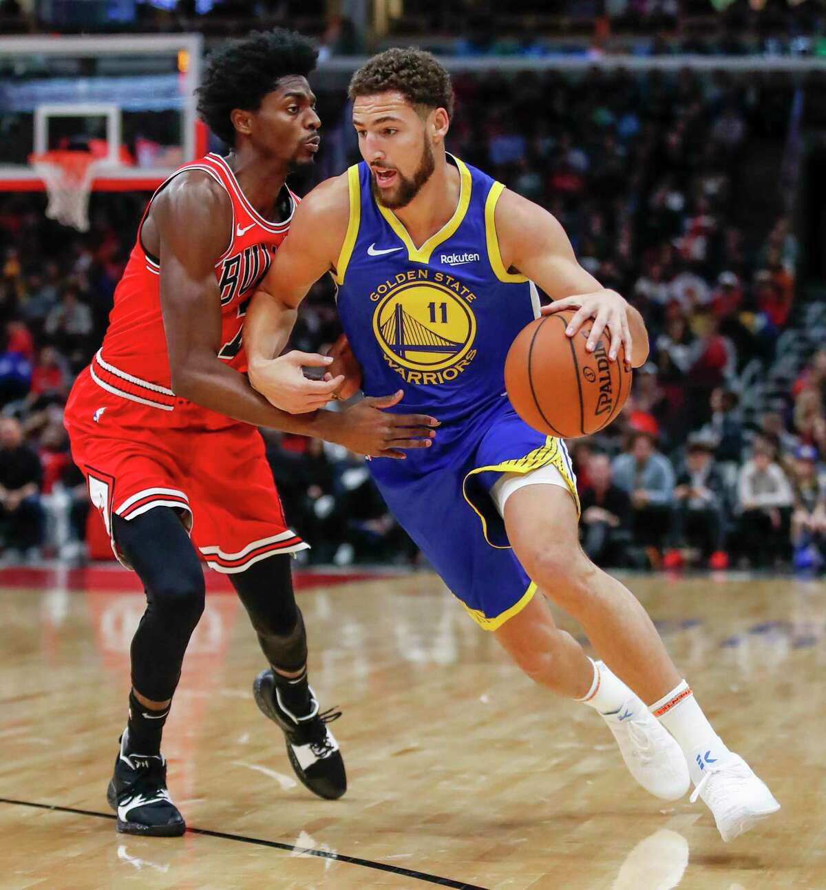 Golden State Warriors guard Klay Thompson, right, drives to the basket against Chicago Bulls forward Justin Holiday, left, during the first half of an NBA basketball game, Monday, Oct. 29, 2018, in Chicago. (AP Photo/Kamil Krzaczynski)