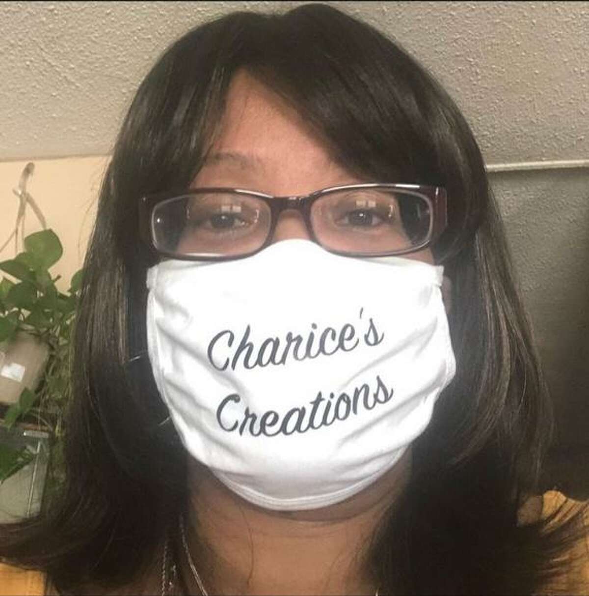 Simone Darby, a nurse who took up crafting to cope with the stress of the pandemic — then turned it into a side business — poses with a mask bearing the name of that business, “Charice’s Creations.” Her middle name is Charice.