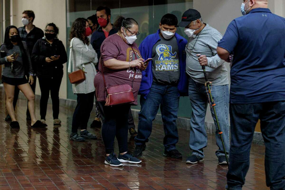 People wait in a long, but quickly moving, line for a free self-administered PCR test at the Wonderland of the Americas in San Antonio, Texas, Friday morning, Jan. 14, 2022. The site will offer free tests Monday through Friday from 8 a.m. to 6 p.m. on a walk-in basis only.