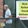 A voter hand delivers his mail ballot at the Bexar County Elections headquarters on Thursday, Oct. 15, 2020. At the same time, at the other end of the building, voters were waiting in line to cast their votes during the third day of early voting.