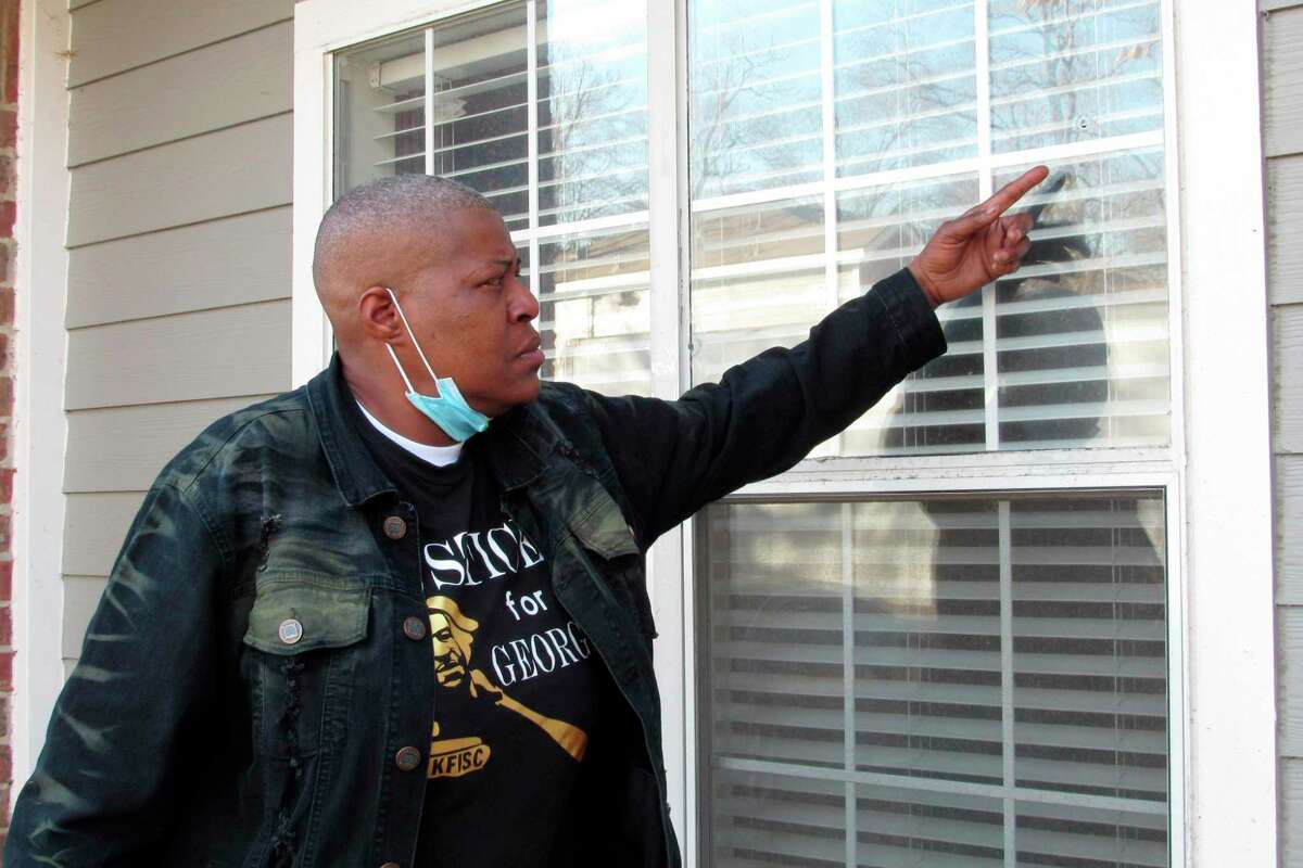 LaTonya Floyd, the older sister of George Floyd, gestures towards a bullet hole in the window of her apartment, Thursday, Jan. 6, 2022, in Houston, as she discussed the New Year’s Day shooting that wounded her and her brother’s 4-year-old grandniece, Arianna Delane.